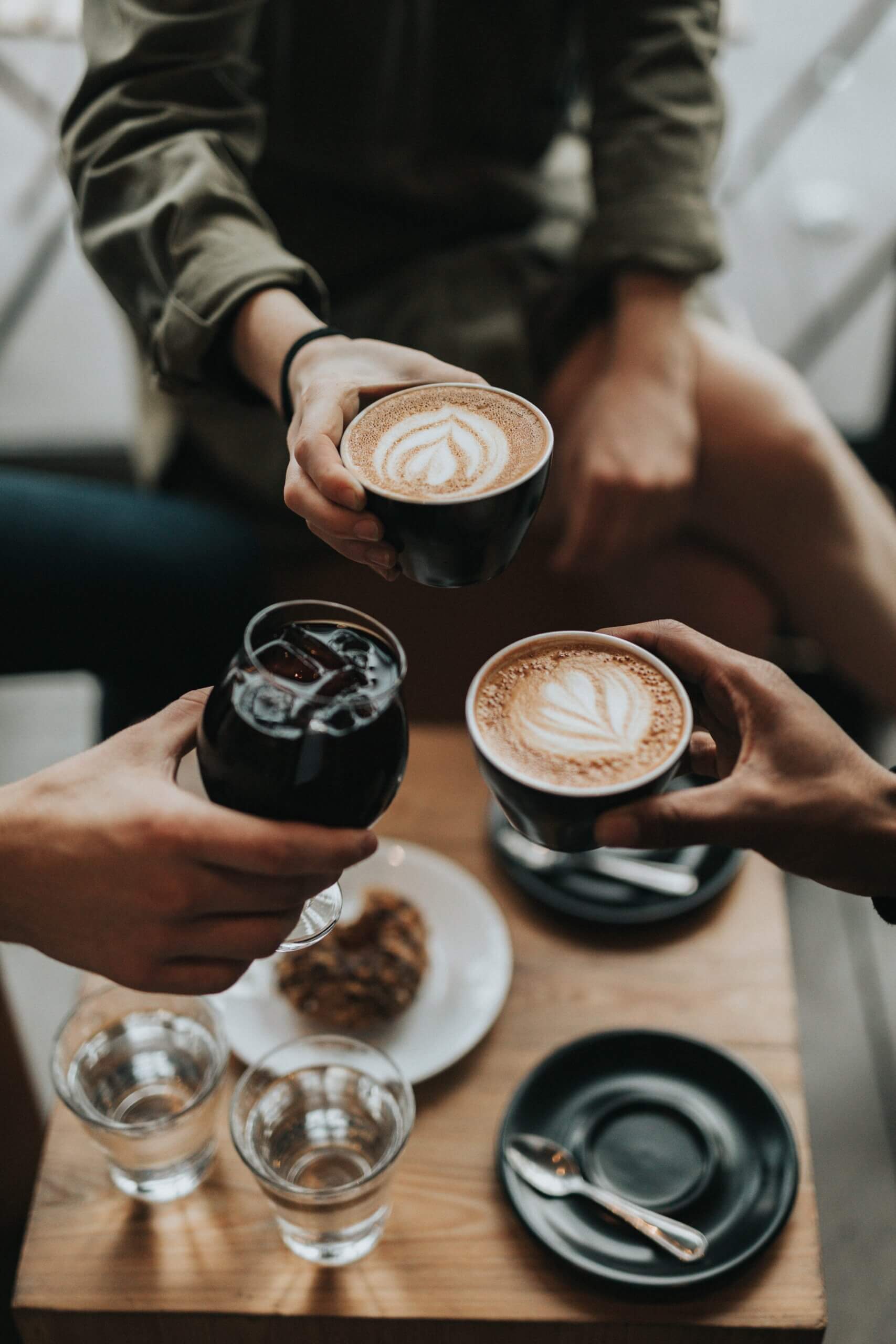 Three people holding cups of coffee