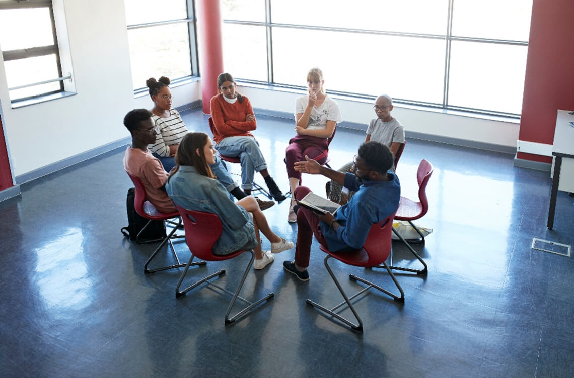 A support group sitting on chairs in a circle formation ACAP Careers social work