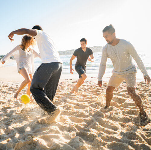 Group of people playing ball on a beach