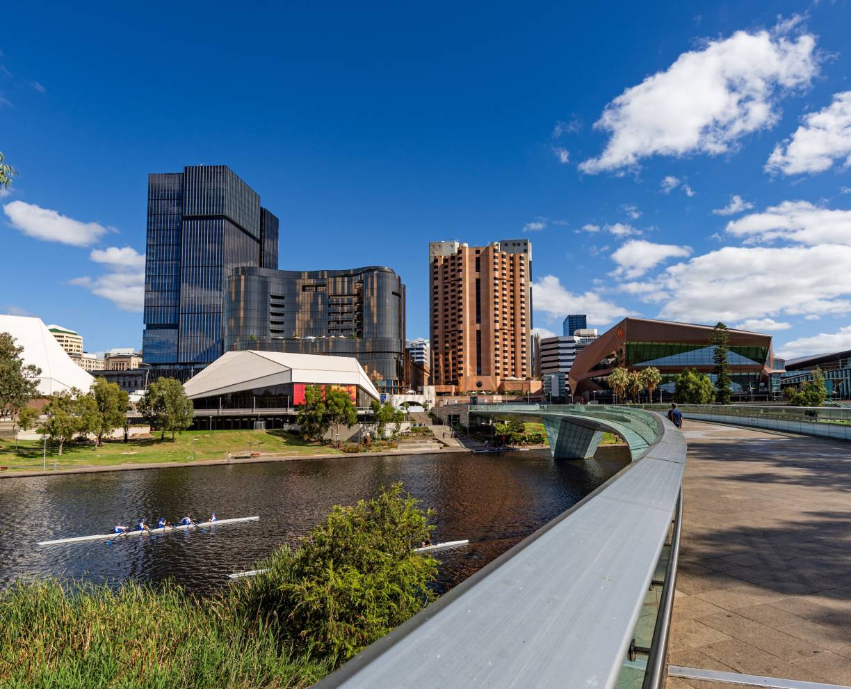 Photo of the ACAP Adelaide campus and surrounding area, with green space, a river and a bridge