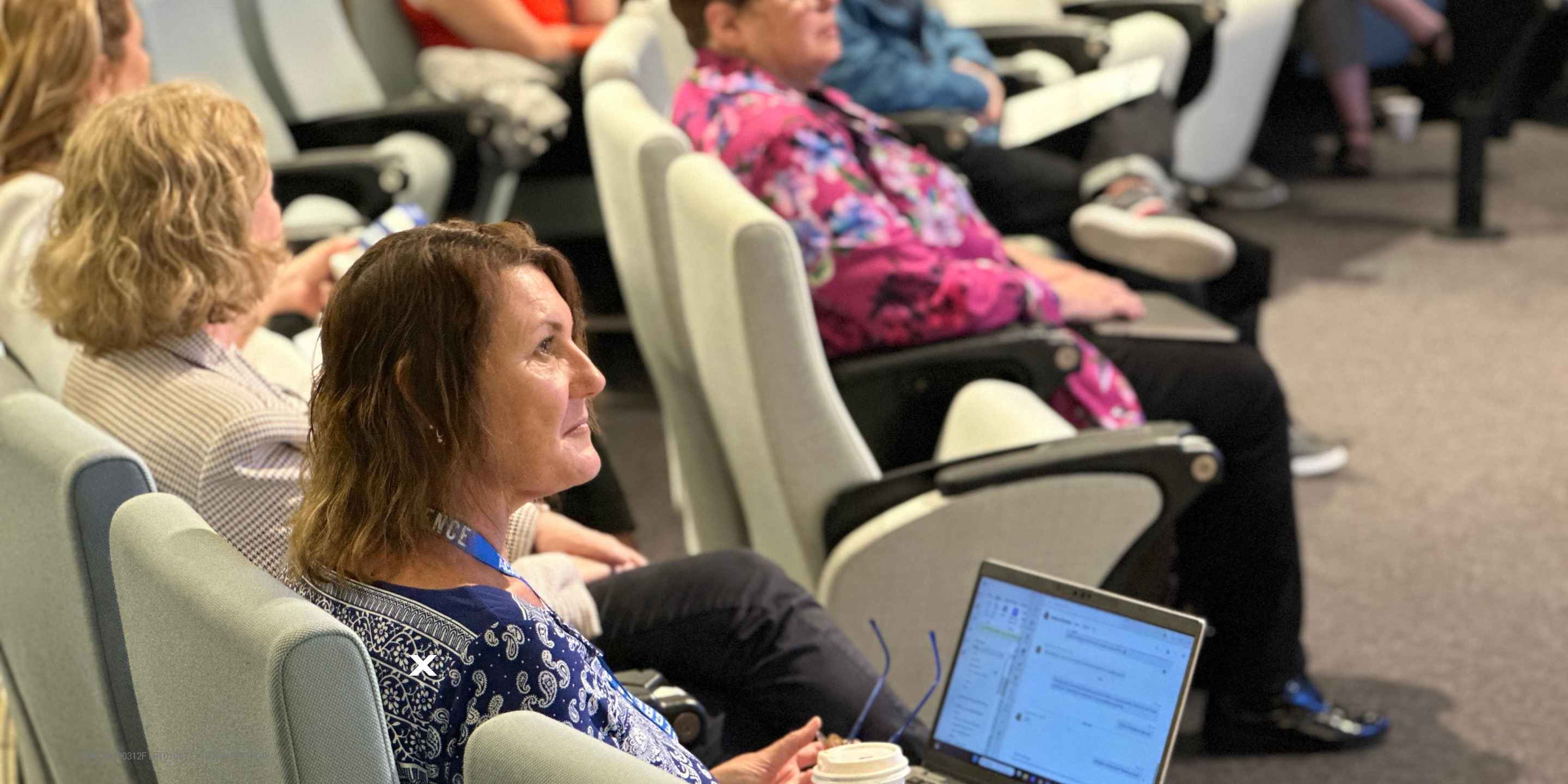 woman sits in lecture theatre