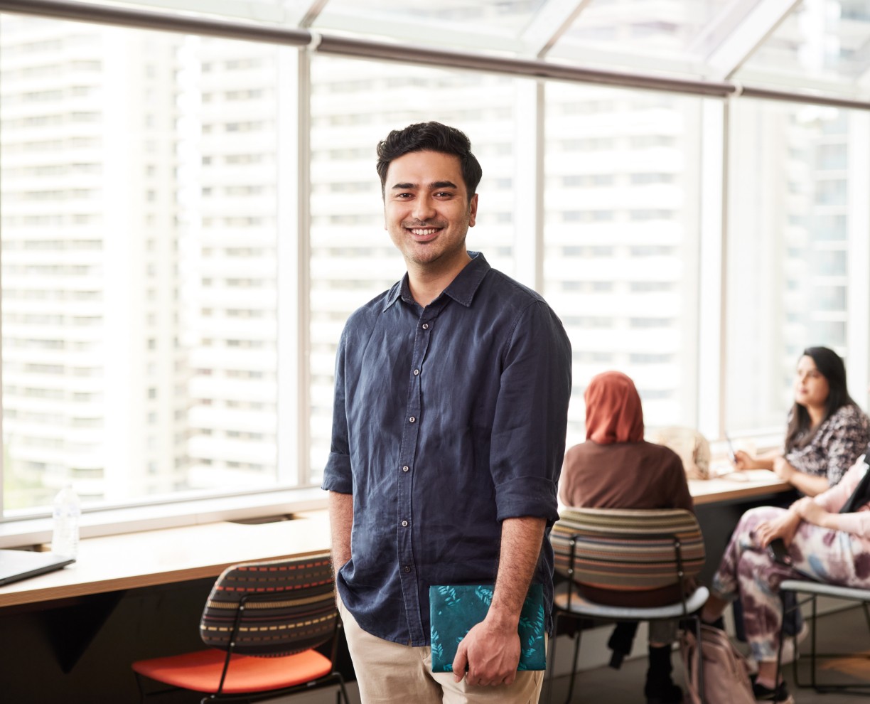 Photo of social work Student Rakesh, standing at ACAP Sydney campus and smiling towards camera