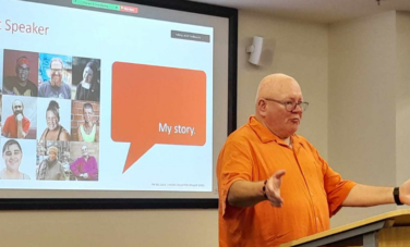 man in orange shirt presenting